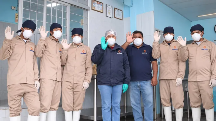 Equipo de Guiver con uniforme, mascarilla y guantes en la planta de beneficio